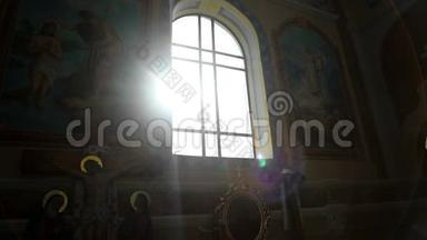 阳光透过教堂的彩色玻璃窗. 在旧教堂里闪烁着阳光的玻璃窗。