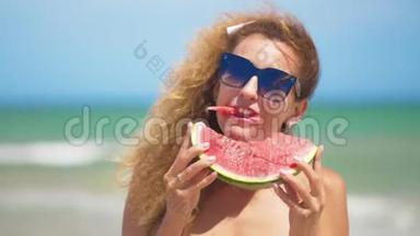 微笑的女人在海滩上吃西瓜。 女人吃美味的夏天水果。 暑假快乐。