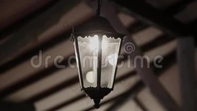 一盏很旧的复古灯照在室内的天花板上。