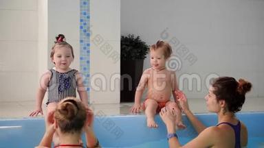 两个婴儿在水池里笑，跳到水里<strong>拍手</strong>