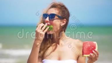 微笑的女人在海滩上吃西瓜。 女人吃美味的夏天水果。 暑假快乐。
