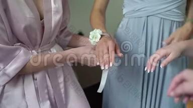 年轻的新娘戴着花镯给伴娘手腕