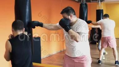 戴手套的人胜过在健身房打拳击。 针对胖子的个人减肥演练.. 拳击训练与