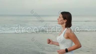 运动女跑步者穿着带<strong>表带</strong>的智能<strong>手表</strong>跑，带空白黑色玻璃弯曲触摸屏的天然海洋海滩