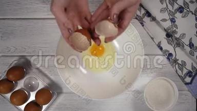 特写镜头，女人`双手把蛋黄从白壳里倒入白盘