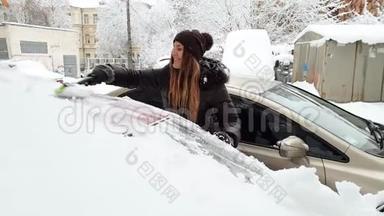 4k视频：美丽的女司机早晨在暴风雪后清理汽车