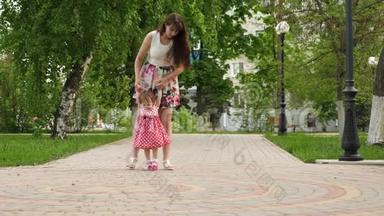 妈妈带着小宝贝去公园。 孩子学会走路。 带孩子的<strong>家长</strong>步行
