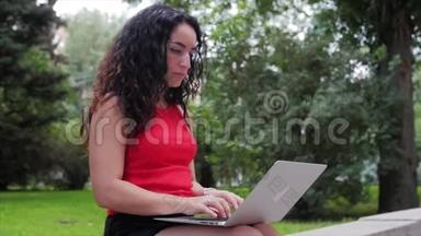 在<strong>笔记本</strong>电脑上工作的女人，穿着黑色短裤的漂亮的布鲁内特，在公园里做着<strong>笔记本</strong>电脑的工作，女孩在她的身上打印出来