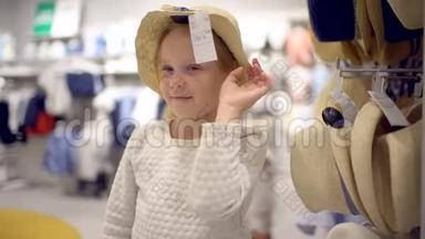 <strong>小</strong>女孩在超市里<strong>挑</strong>选衣服。 快乐的一家人在购物。 在商场里的家人。 <strong>挑</strong>选婴儿帽
