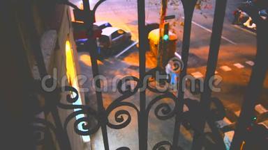 黄昏时分，透过一楼阳台上美丽的锻铁看守者望着街道，
