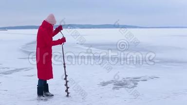 穿着红色保暖夹克和毛毡靴的漂亮渔夫们在<strong>冰冻</strong>的河流中用冰钻为冰上捕<strong>鱼</strong>打了个洞