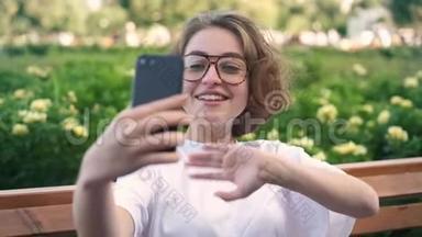 可爱的女孩在眼镜视频呼叫或vlog夏季公园。