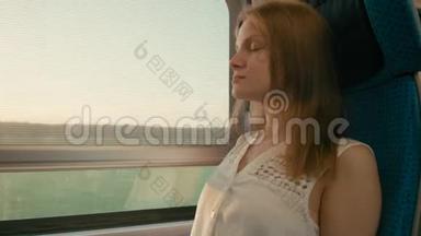 年轻女子乘火车在日落时看着窗外