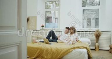舒适的卧室，一对夫妇<strong>一起看电影</strong>和吃爆米花。
