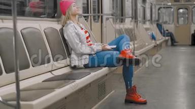 那个有趣的迷人的、快乐的金发女孩在地铁的地铁里跳舞。 那个女人正在听音乐