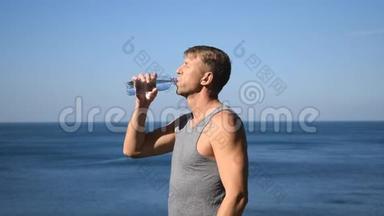 一个人从海洋上的塑料瓶里喝水，运动后解渴