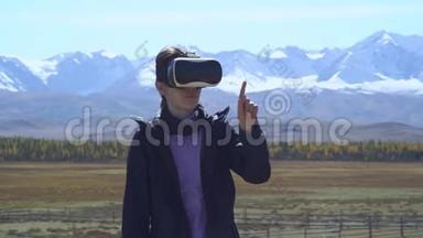 头盔中的女孩虚拟现实VR在山顶上召唤着夏日的风景