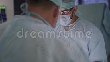 两名医生在手术期间穿着无菌衣服和口罩。 手术室的外科医生。