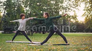 有经验的教师苗条的女孩在城市公园温暖的秋日教她的女<strong>学生瑜伽</strong>体式