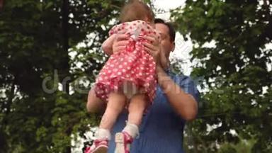 快乐的婴儿在教皇的<strong>手中</strong>盘旋在空中，在夏季公园欢笑。 慢动作