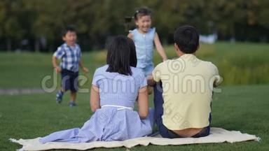 可爱的亚洲<strong>孩子温柔</strong>地拥抱公园里的父母