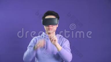 年轻人在深蓝色背景下玩虚拟现实游戏。 中国年轻人戴着VR耳机。
