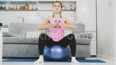 那个女孩坐在球上做<strong>各种体育</strong>锻炼。