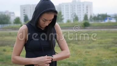 女人为跑步设置健身智能手表。 女运动员检查手表