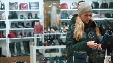 年轻的少女在商店里挑选鞋子。