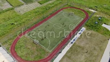 鸟瞰儿童在一个小足球场上踢足球.. 学校附近的现代足球场