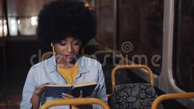 年轻的非裔美国妇女或坐在<strong>公共交通工具</strong>上的乘客读物，ste dicam拍摄。 慢动作。 城市