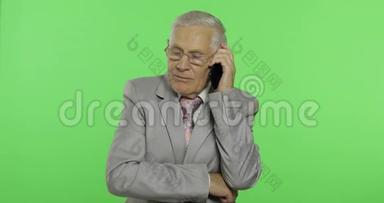 英俊的老年商人在智能手机上交谈。 穿西装的<strong>老头</strong>