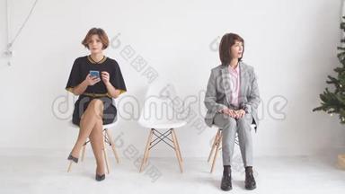 三个女商人希望在办公楼走廊的椅子上接受<strong>采访</strong>。