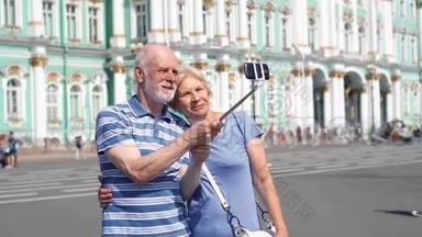 在俄罗斯圣彼得堡，皇宫广场上的老夫妻在度假时用手机自拍