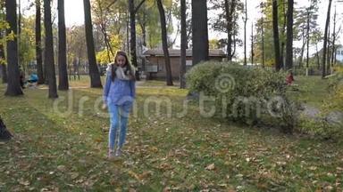 美丽的年轻女子戴着针织围巾，在<strong>秋天</strong>的公园散步。 <strong>视频</strong>运动
