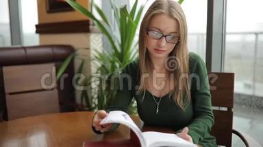女人坐在咖啡馆里翻书