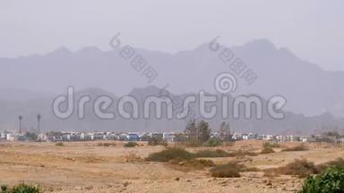 在埃及背景的沙漠山脉中的建筑物和房屋的全景。