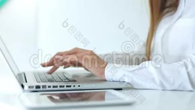 女商人`在白色办公室用笔记本电脑打字的特写镜头