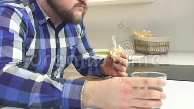 穿格子衬衫留着胡子的胖子吃快餐芝士汉堡，用有害的柠檬水冲洗，额外的卡路里