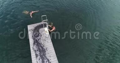 三个训练有素的人早上在室外跳入水中的无人机镜头