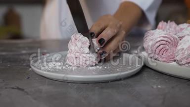 年轻女子在厨房用刀切棉花糖。