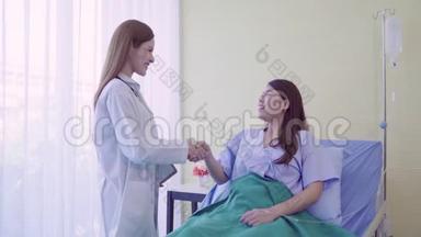 亚洲医生和病人在病人`的床上躺着时，用手中的剪贴板讨论和解释一些事情。