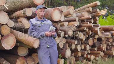 工人伐木工人或木匠，在一堆木头附近有一大堆钱，锯木头。 成功的概念