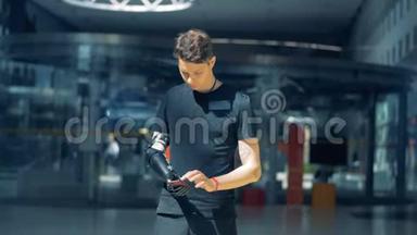 一个人拿着一部手机，用他的控制假肢，用它工作。 cyborg概念。