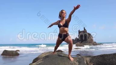 与自然和谐相处的女人站在海边的石头上沉思