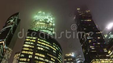 摩天大楼和商务中心的办公室窗户在一个多雾的夜晚，时间流逝，高度流逝