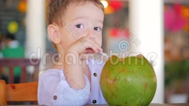 可爱的孩子喝椰子槽吸管，近距离。概念：孩子，快乐的<strong>童年</strong>，夏天，孩子，假期。