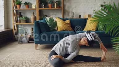 戴着虚拟现实眼镜的微笑女孩正在家中训练坐在地板上伸展腿部和身体，享受AR