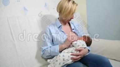 妈妈母乳喂养，拥抱宝宝.. 年轻的母亲在家里的蓝白色房间里喂她的婴儿。 妈妈