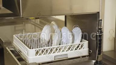 关闭，在自动洗碗机的篮子上的白色盘子，用于工业，洗碗机在厨房自助餐厅